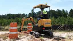 Image of a SANY SY16C Excavator Left Rear Facing Digging Trench