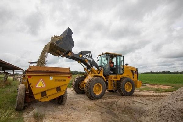 Wheel Loader dumping dirt into the back of trailer