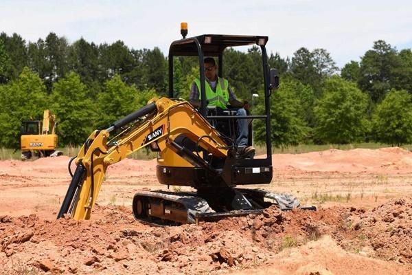 Man operating compact excavator