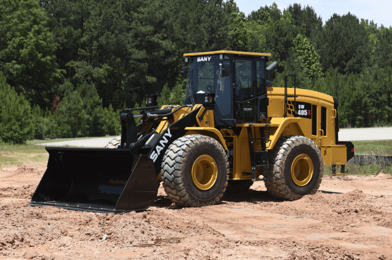 The wheel loader is staged outside in a dirt patch
