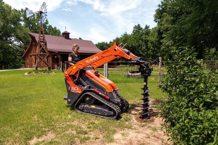 Kubota SCL1000 Stand-On Compact Loader with 9″ or 12″ Post Hole Digger